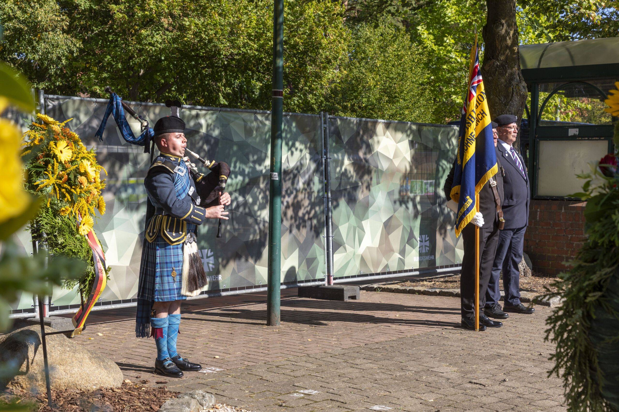 Flight Leutnant Greg Harley spielte zum Abschluss der Gedenkveranstaltung ‚Flowers of the Forest’ vor den Kränzen und der Standarte der Royal British Legion aus Bergen-Hohne.